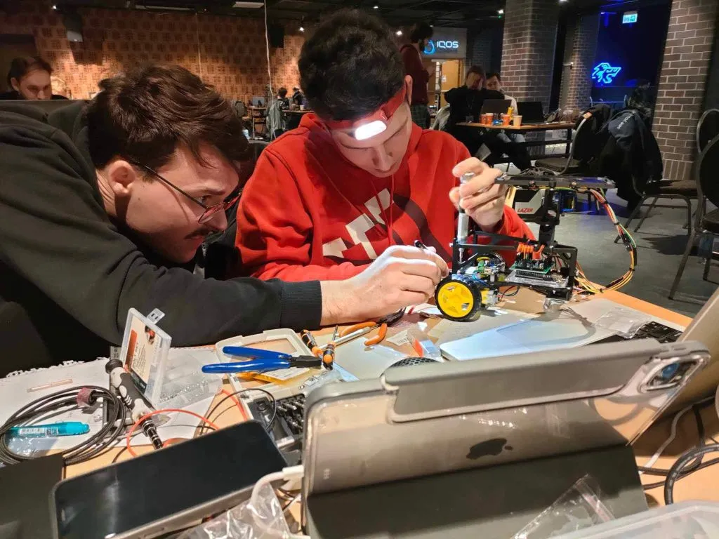 Studenci pracują nad konstrukcją robota w trakcie BITEhack 2024
